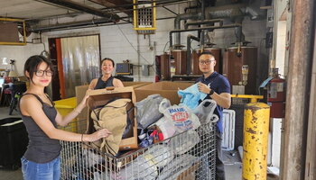 A photo of Sophie Chiewtrakoon and other scholars sorting objects in a large bin