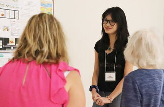 A photo of Sophie Chiewtrakoon presenting research to two other people