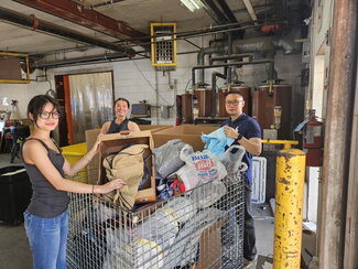 A photo of Sophie Chiewtrakoon and other researchers sort objects in a large bin