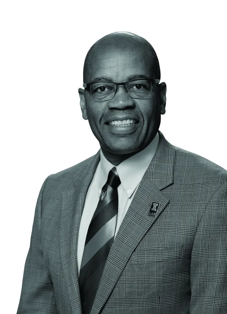 A black-and-white image of Reuben May smiling at the camera.