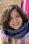 Soodeh Mansouri wears a colorful knit scarf and smiles at the viewer.